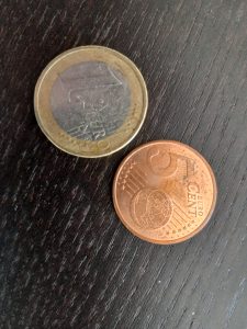 Portuguese 5 cent coin and 1 Euro coin.